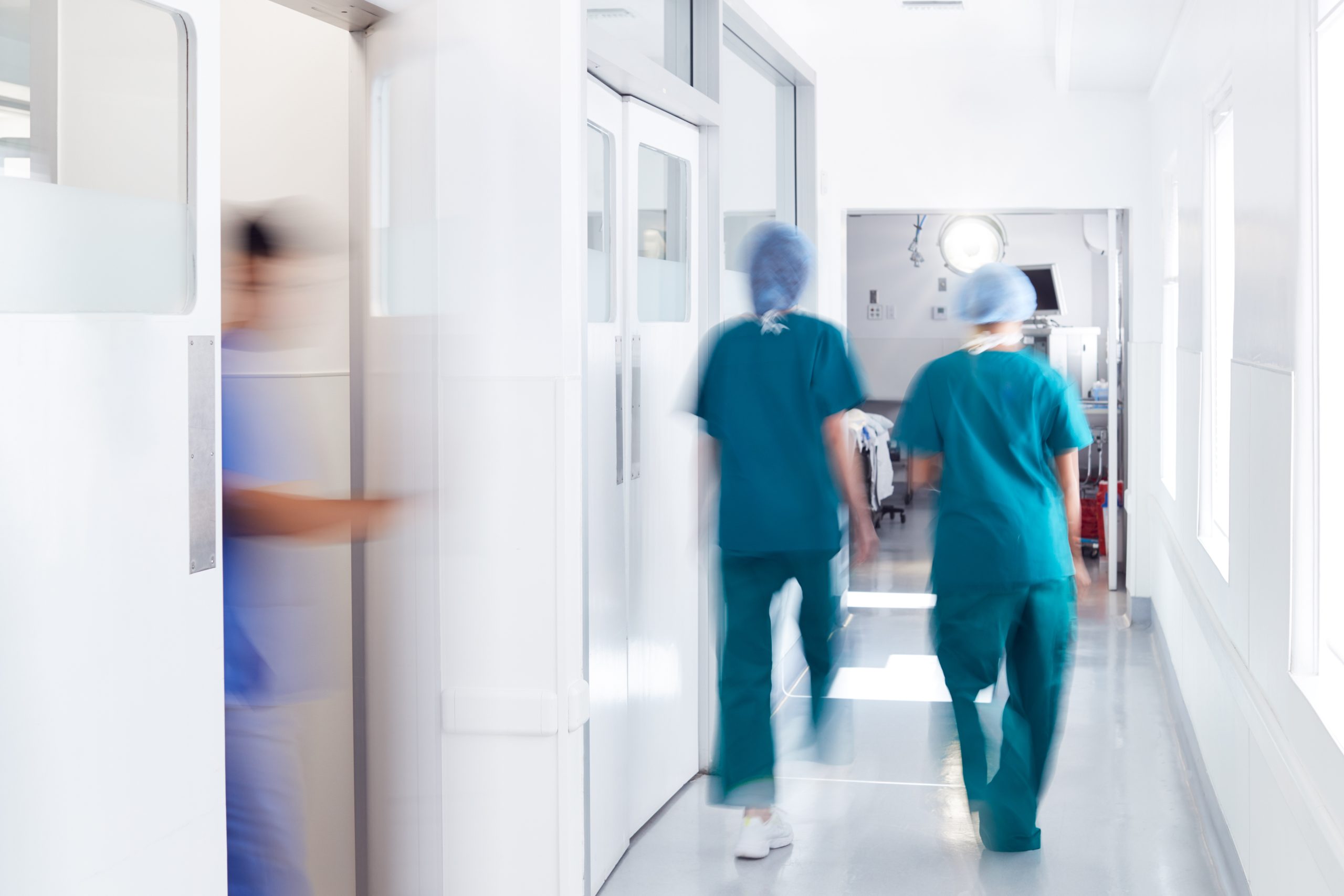 Klinikpersonal die den Flur entlang läuft